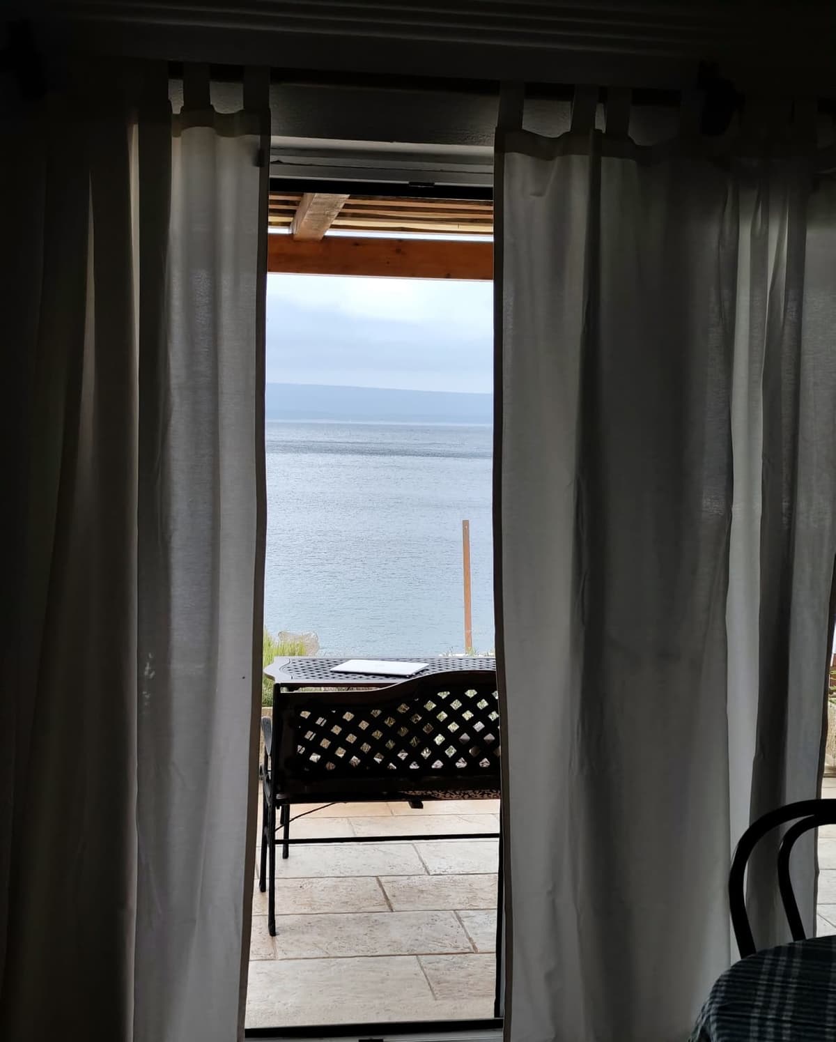 Sea view framed by curtains from the living room