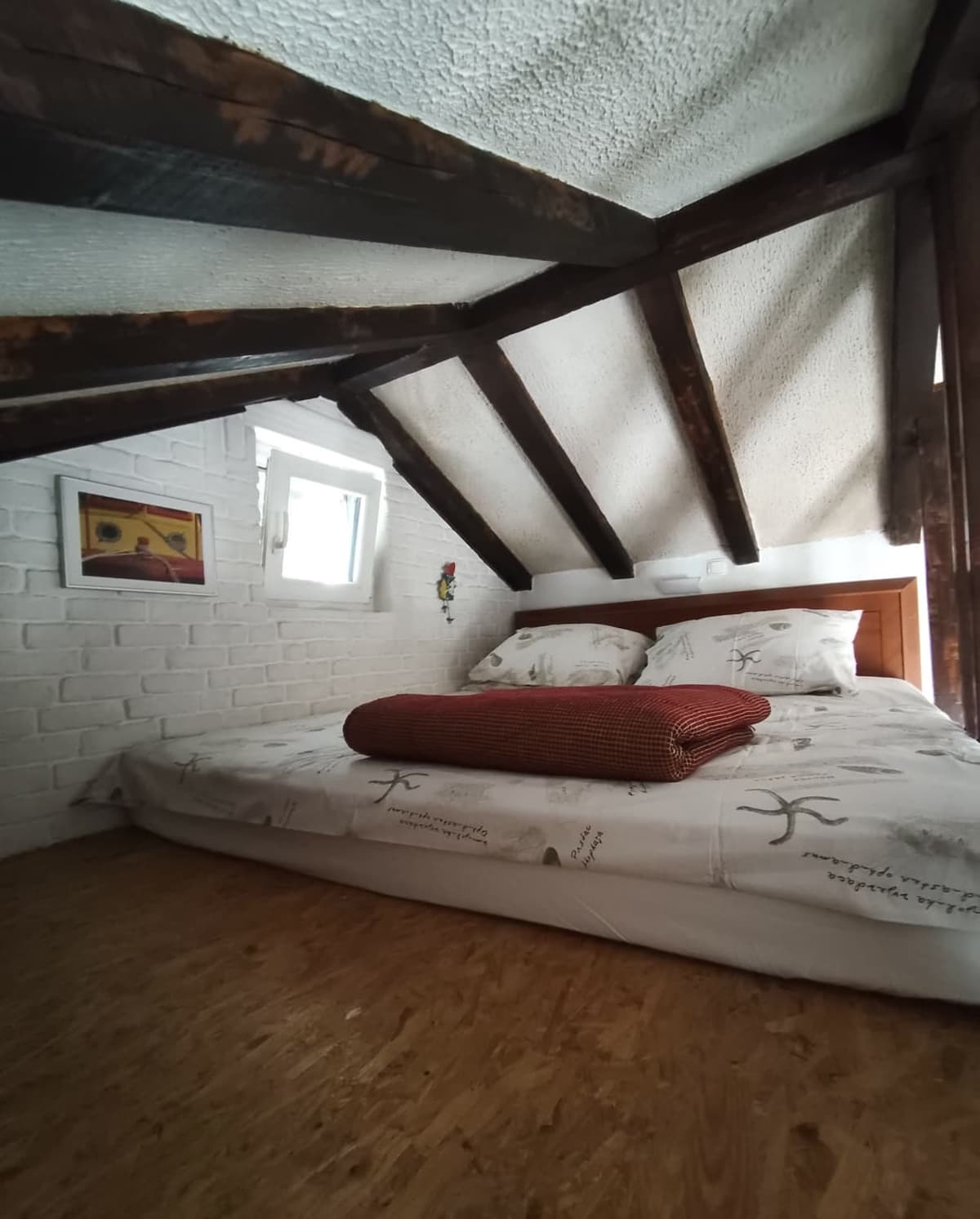 Loft sleeping area framed by wooden beams